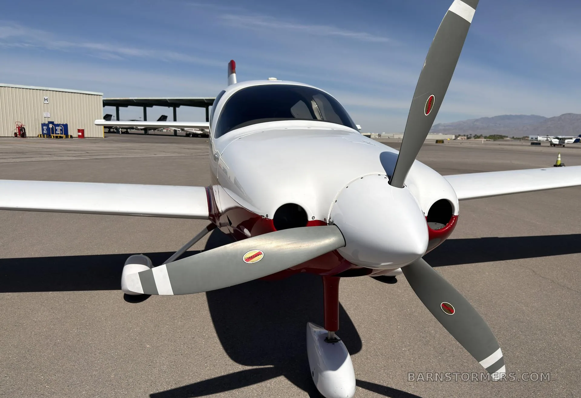 Front view of a white and red single-engine aircraft, N349RF, showing its propeller and nose.