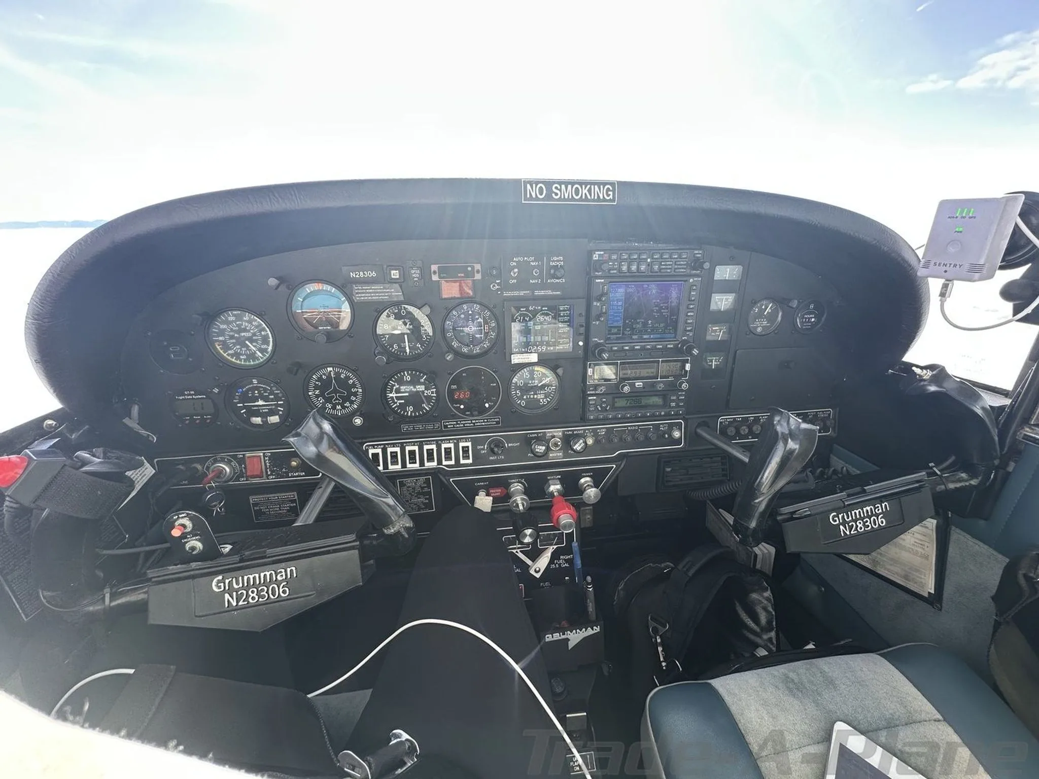 A wide view of the Grumman AA5B Tiger's cockpit, N28306, showing the instrument panel, yokes, and front seats.