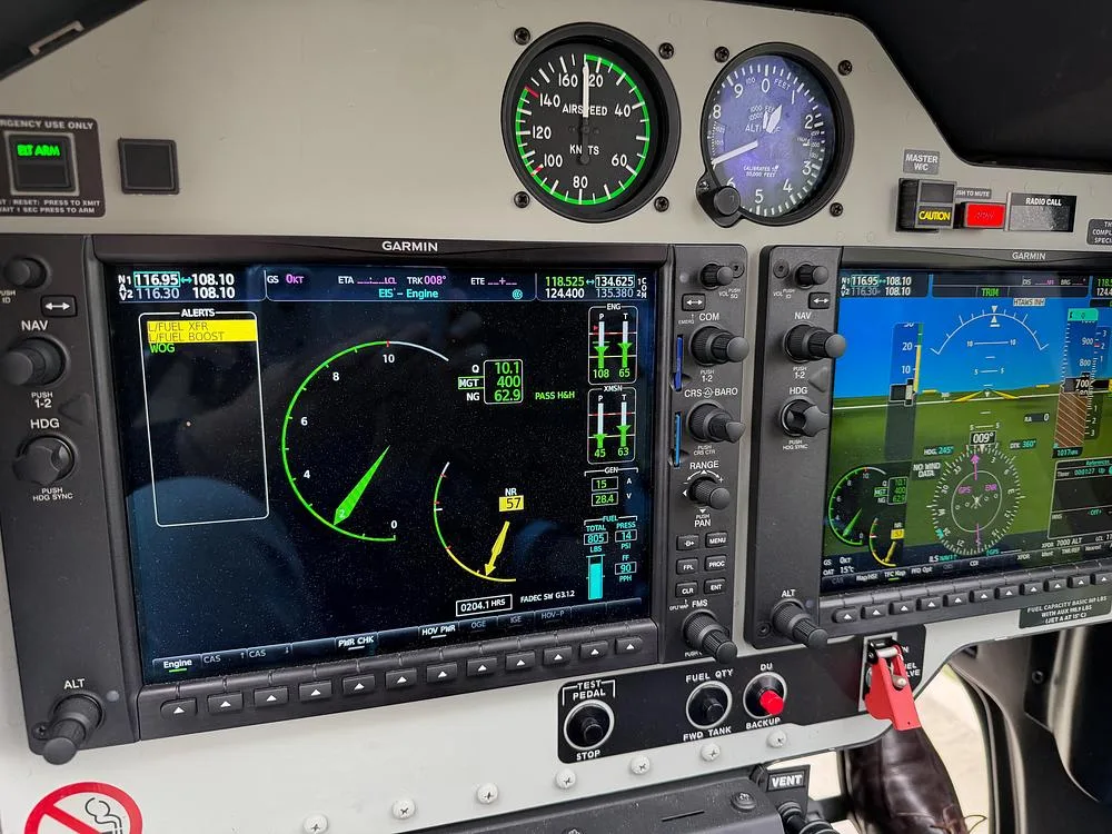 A close-up view of the helicopter's Garmin avionics screens displaying flight and engine data.