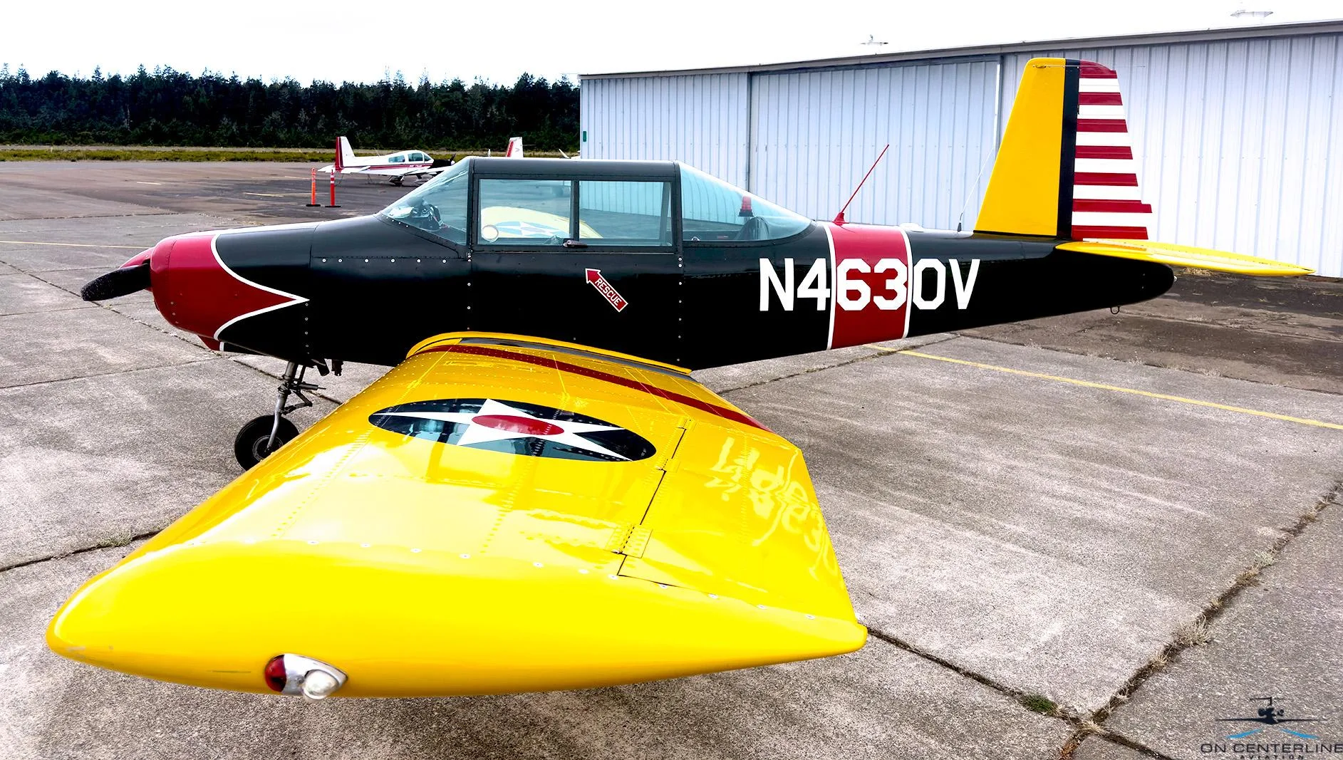 A front-side view of the N4630V aircraft, emphasizing the yellow wing with a US star insignia and the red propeller cone.