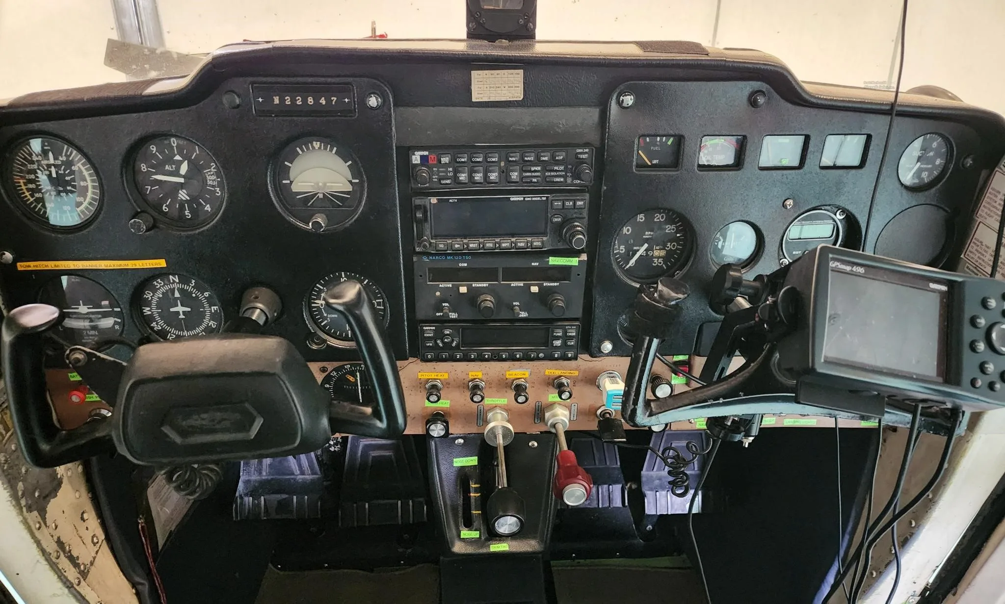 The instrument panel of a Cessna 150, showing various gauges, radios, and a GPS unit.