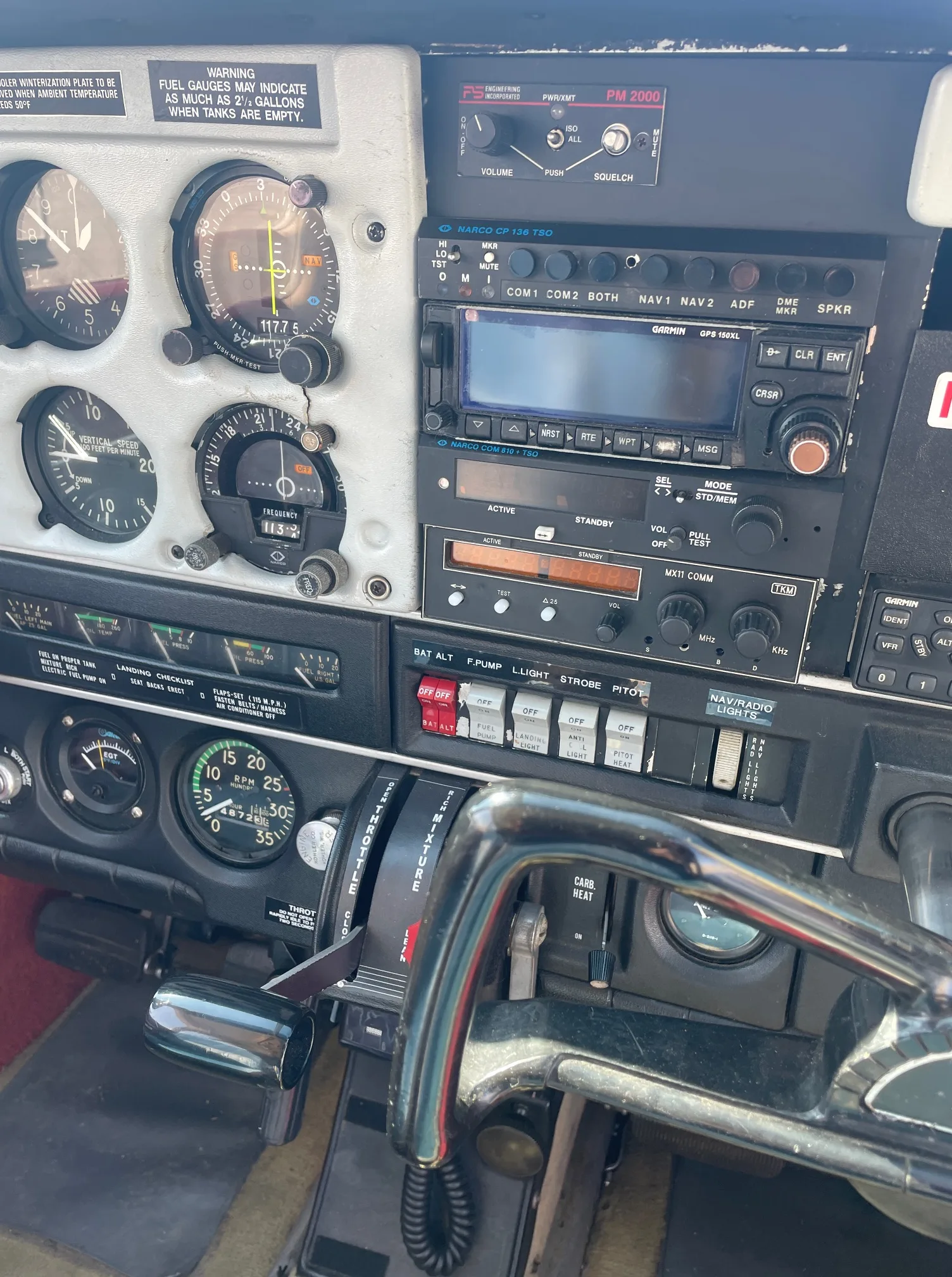 Detailed view of an aircraft's instrument panel, radio stack, and control levers.