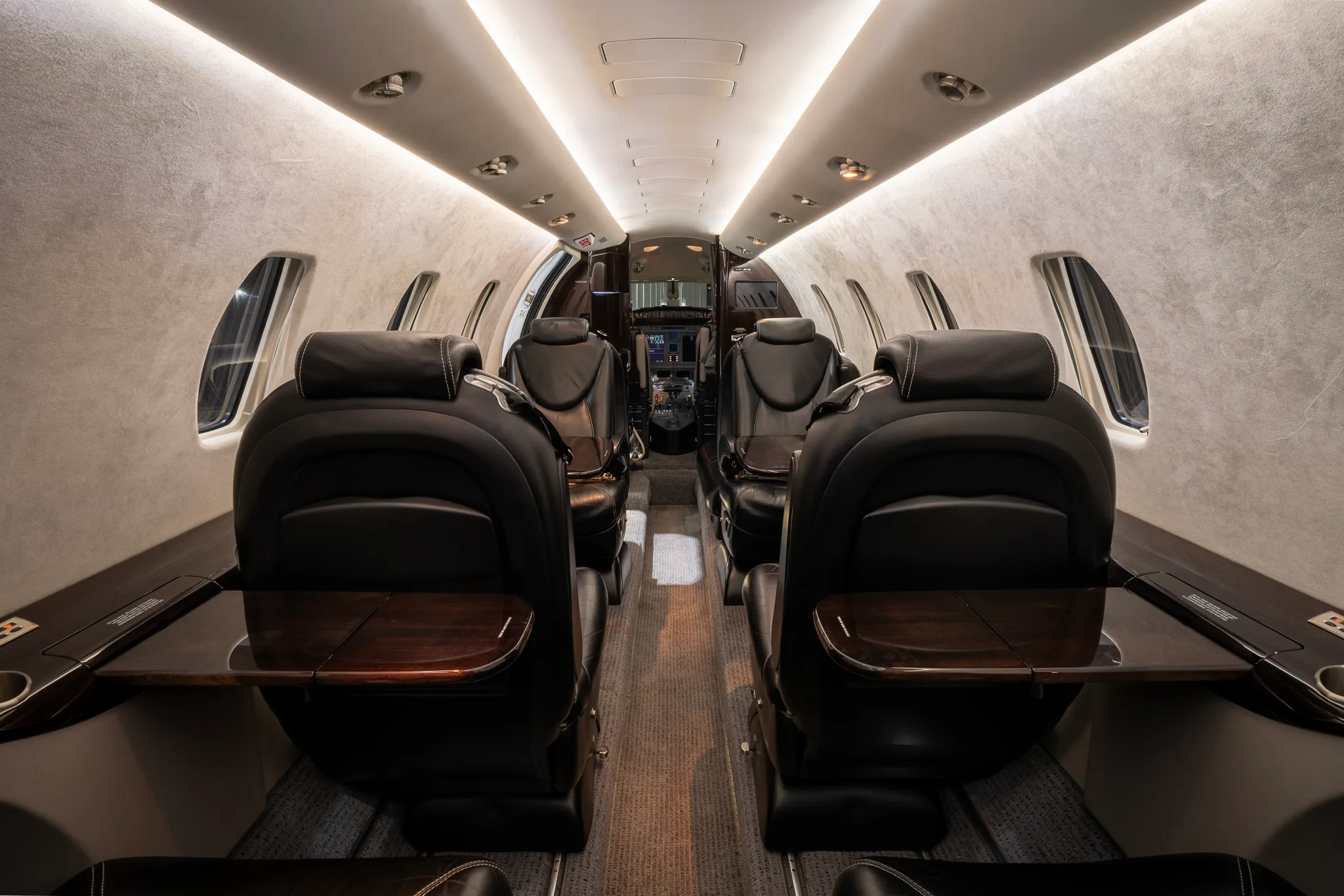 View of the Cessna Citation XLS+ cabin looking forward with tables extended.