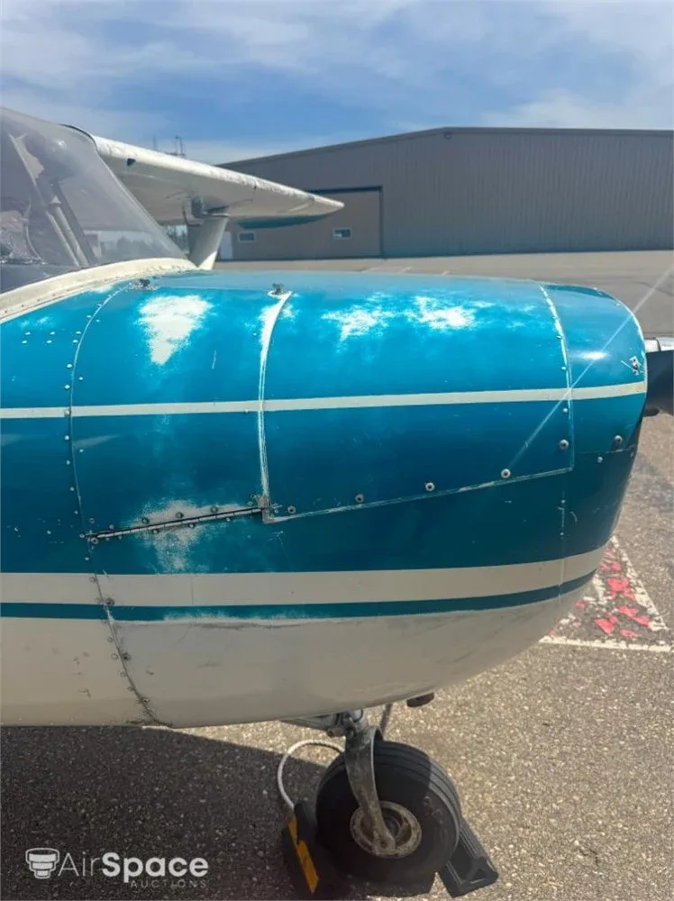 Close-up of the front fuselage and cowling of a Cessna 150, showing the weathered blue paint.