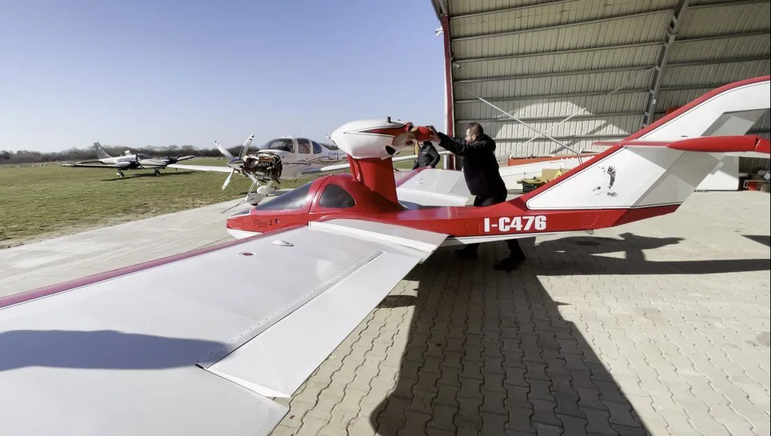 Osprey 2 aircraft with red and white paint scheme in a hangar.