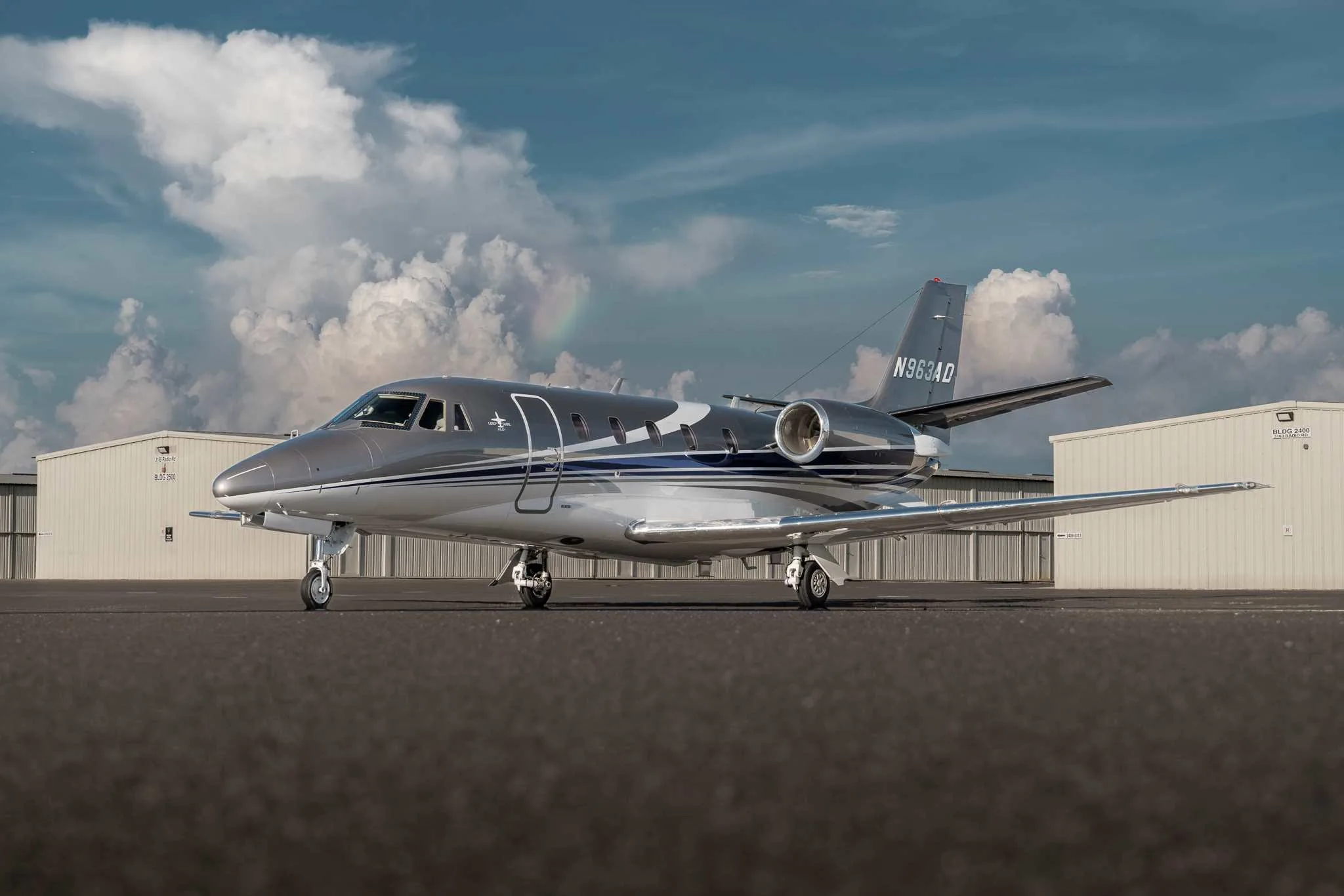 Cessna Citation XLS+ aircraft on the tarmac with a rainbow in the background.