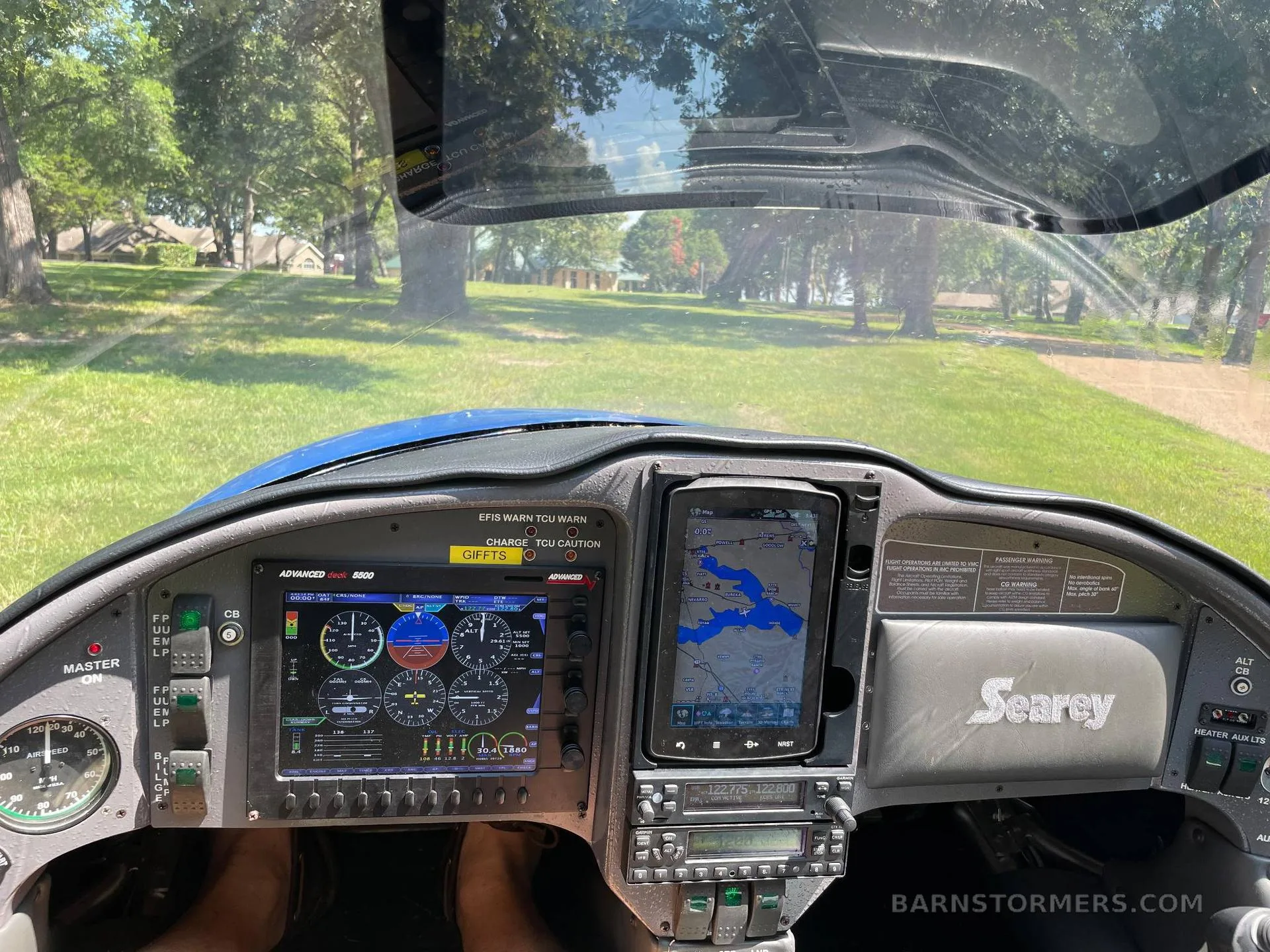 The cockpit of a Searey aircraft showing the instrument panel with a digital display, a tablet with a map, and controls.