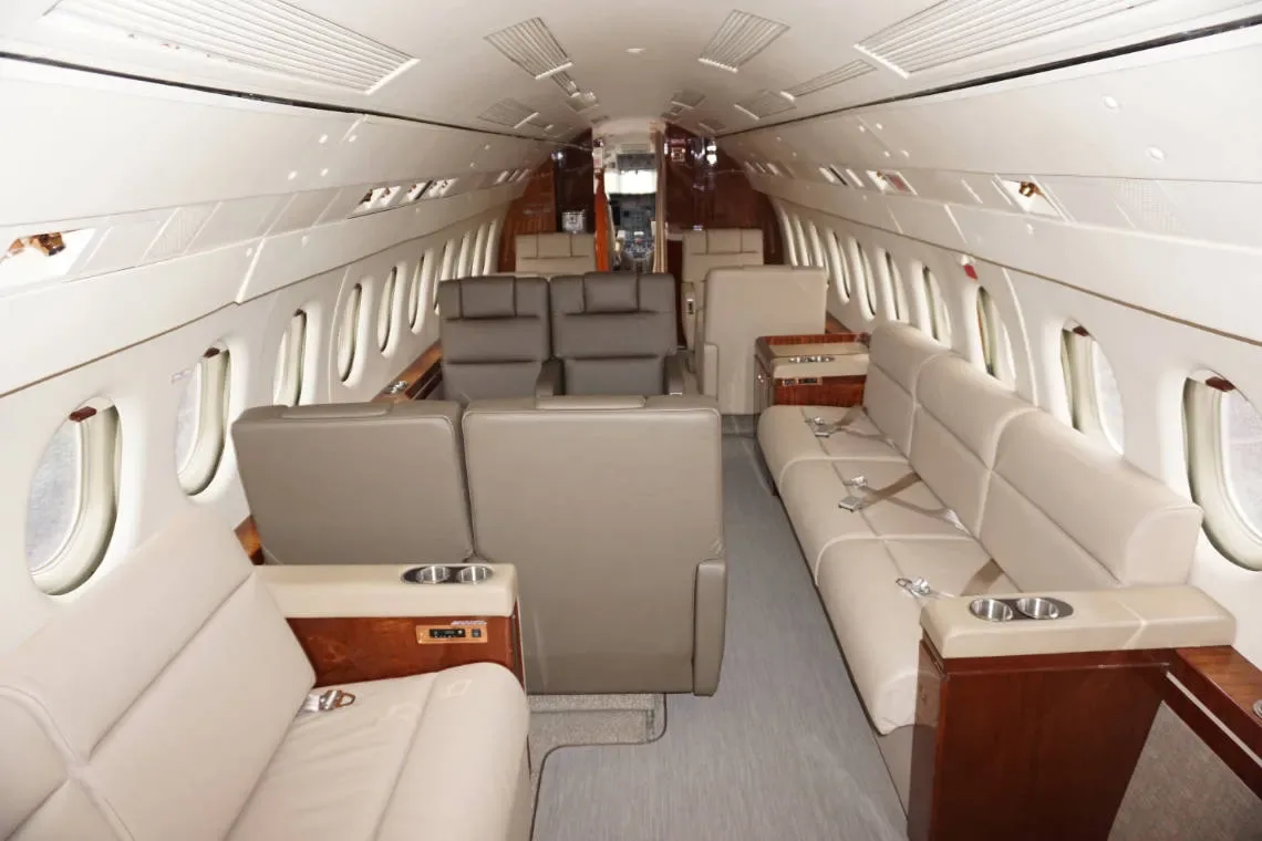 The aircraft's interior features leather seats and wood trim.