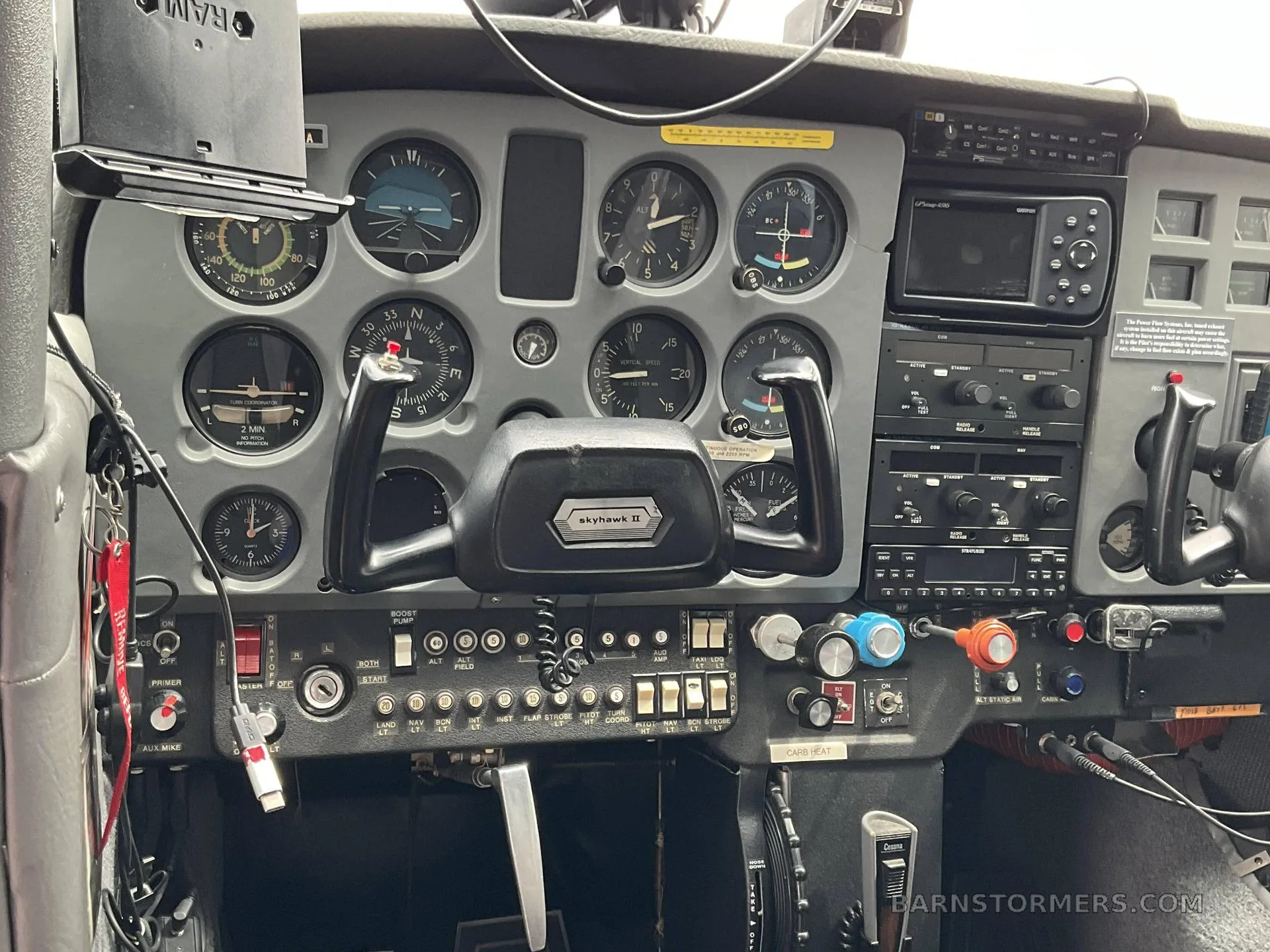 The cockpit instrument panel of a Cessna Skyhawk II with analog gauges and modern avionics.