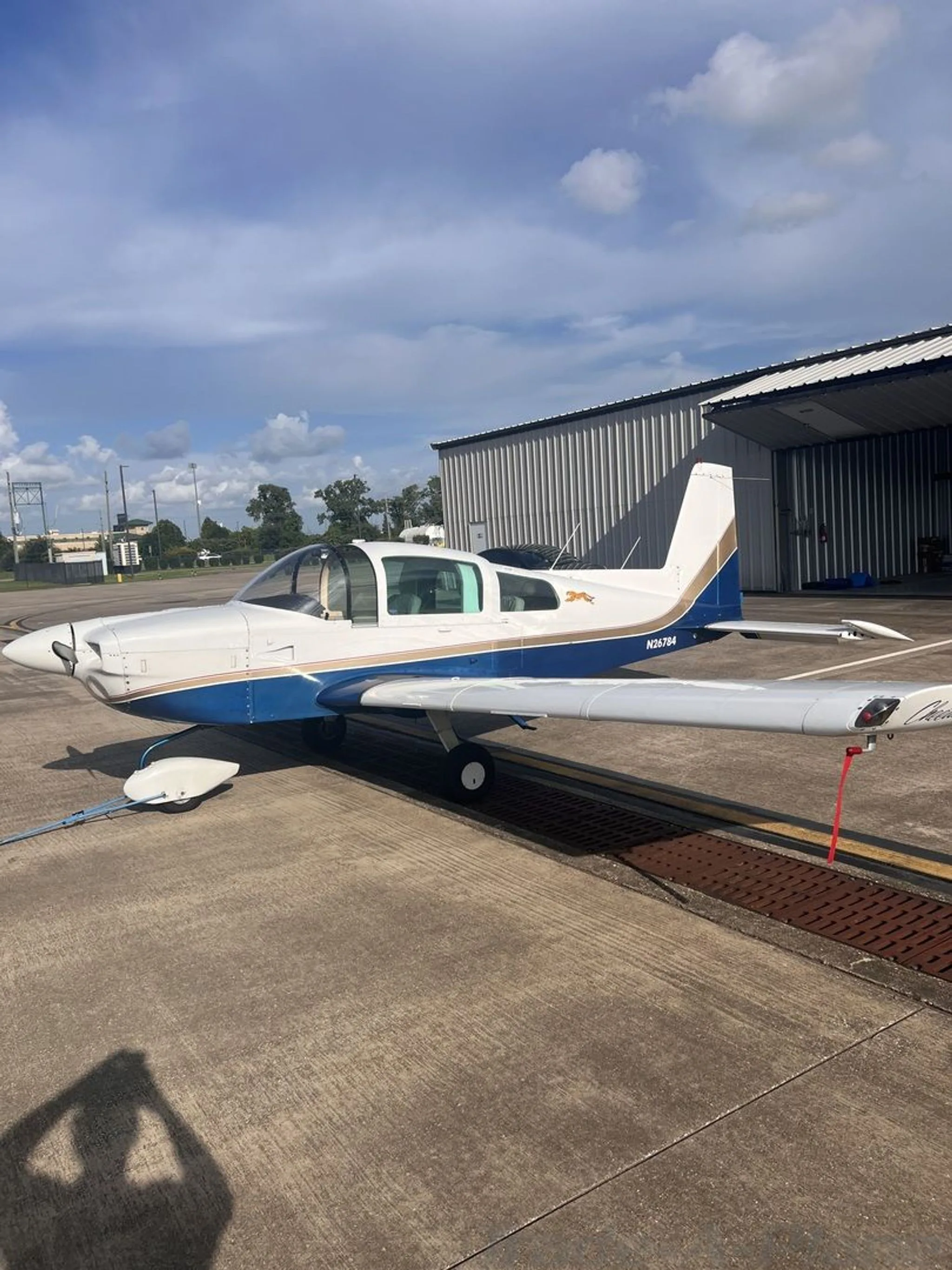 A side view of the aircraft parked at a hangar.