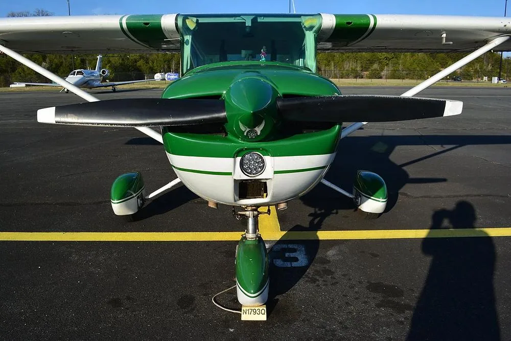A head-on view of a green and white Cessna 172 aircraft, registration N1793Q, showing its propeller and nose landing gear.
