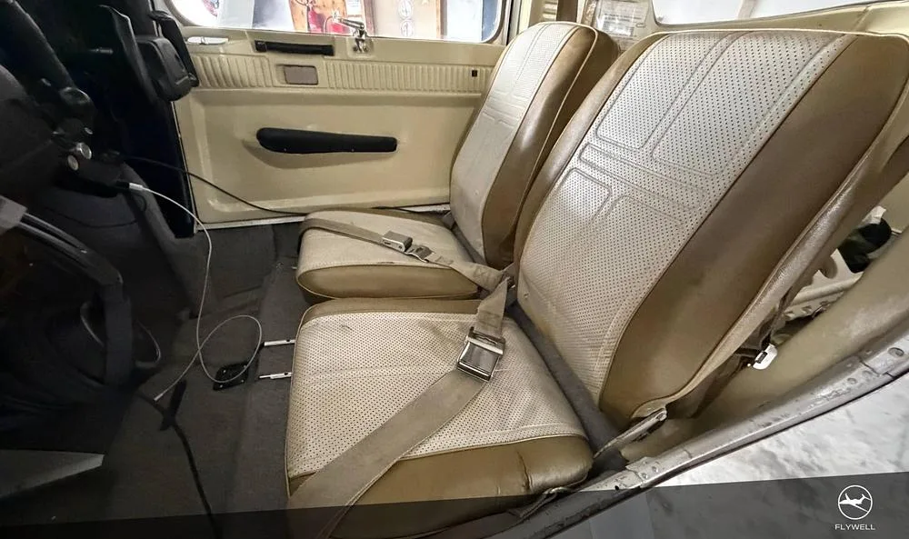 The tan and white perforated leather seats in the cabin of a small aircraft.