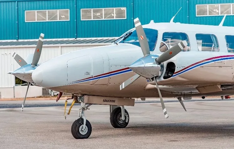 Close-up of the nose and landing gear of a twin-engine aircraft.