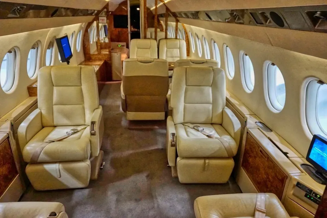 Interior view of the aircraft cabin with leather seats and wood trim.