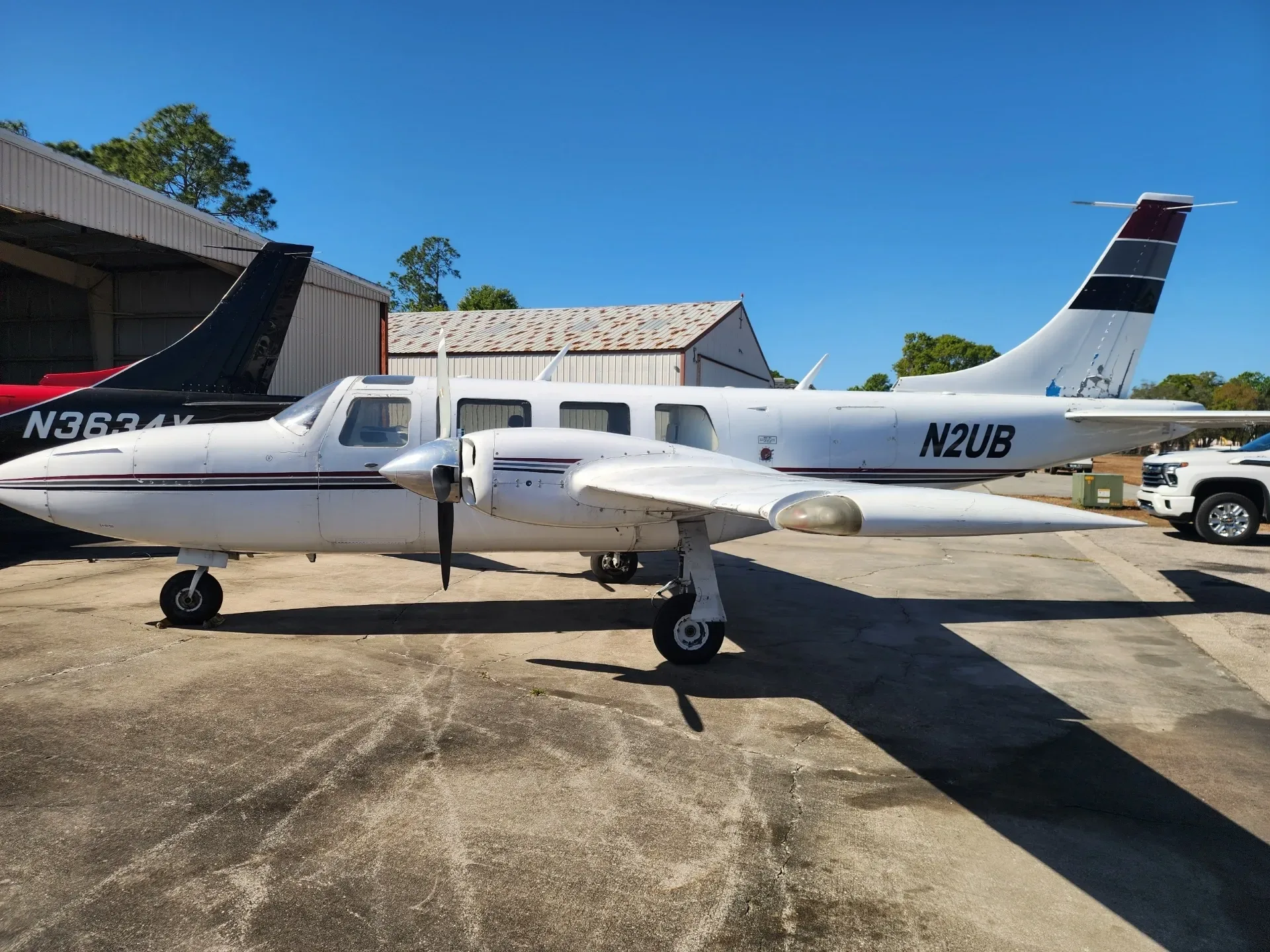 Side view of the N2UB aircraft with white and black paint scheme parked on an airfield.