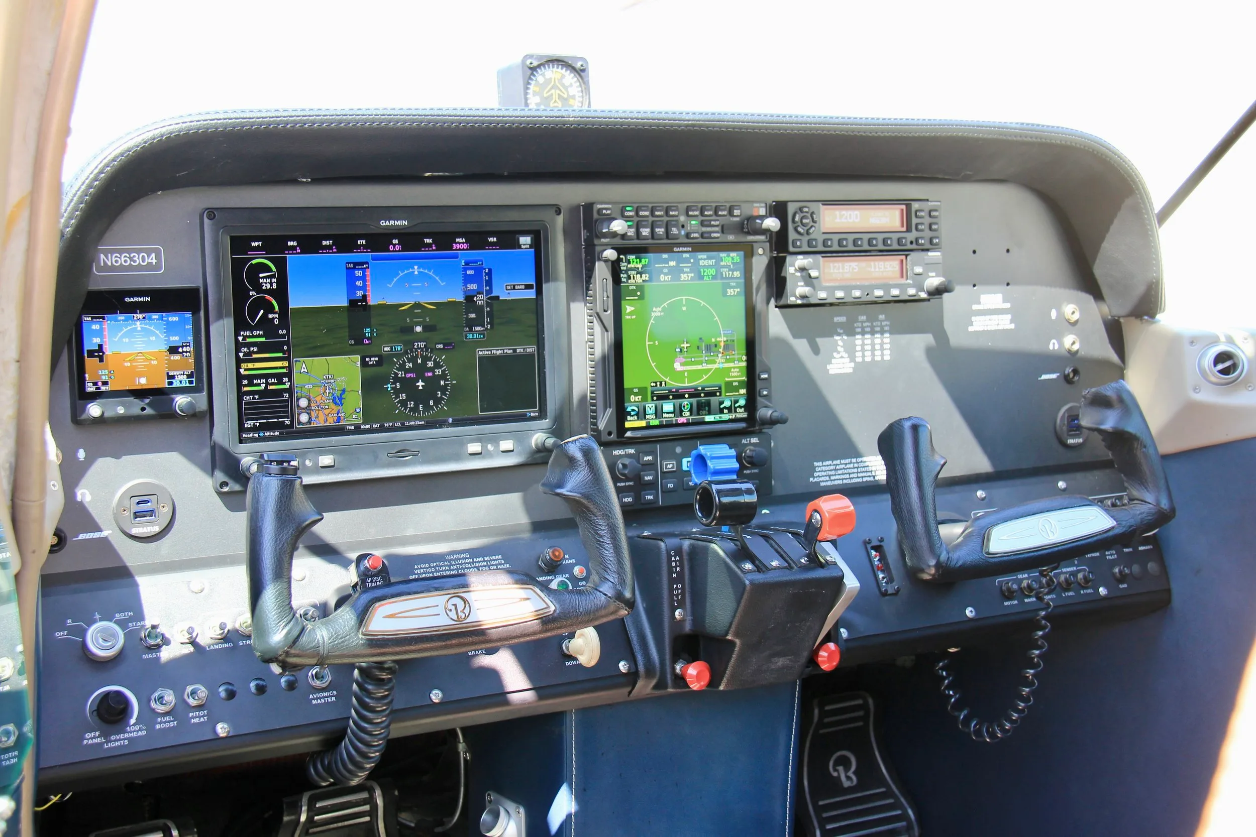 The cockpit of N66304, featuring modern Garmin avionics displays and dual yokes.