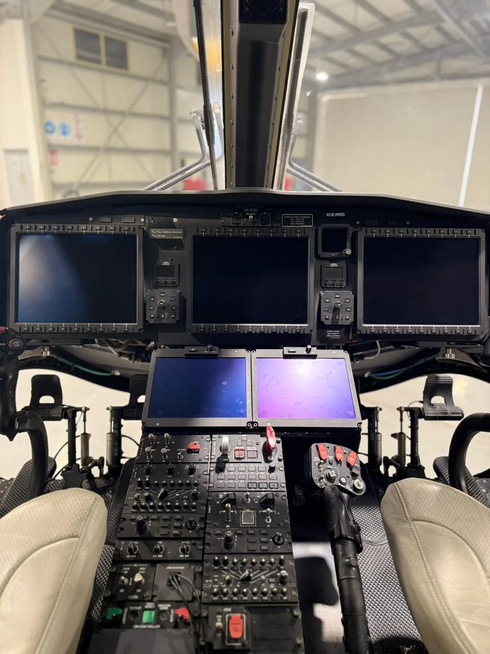 Close-up of the A6-FHG helicopter cockpit instrument panel and controls.