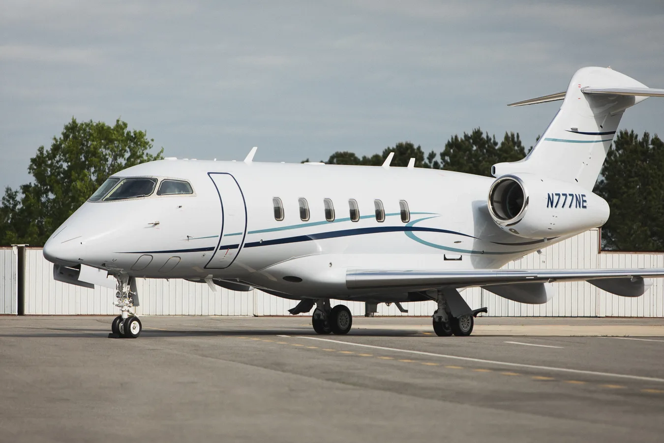 Side view of N777NE Challenger on the tarmac.