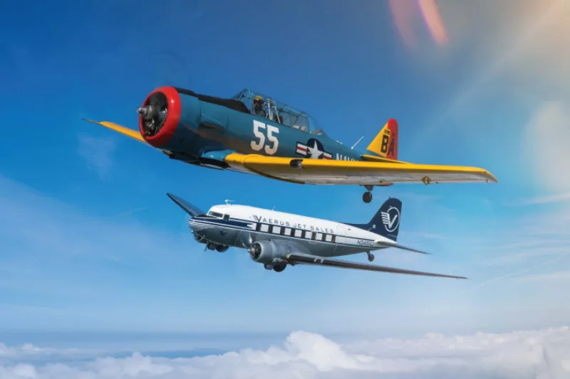 A T-6 Texan and a Douglas DC-3 fly in formation over the clouds.