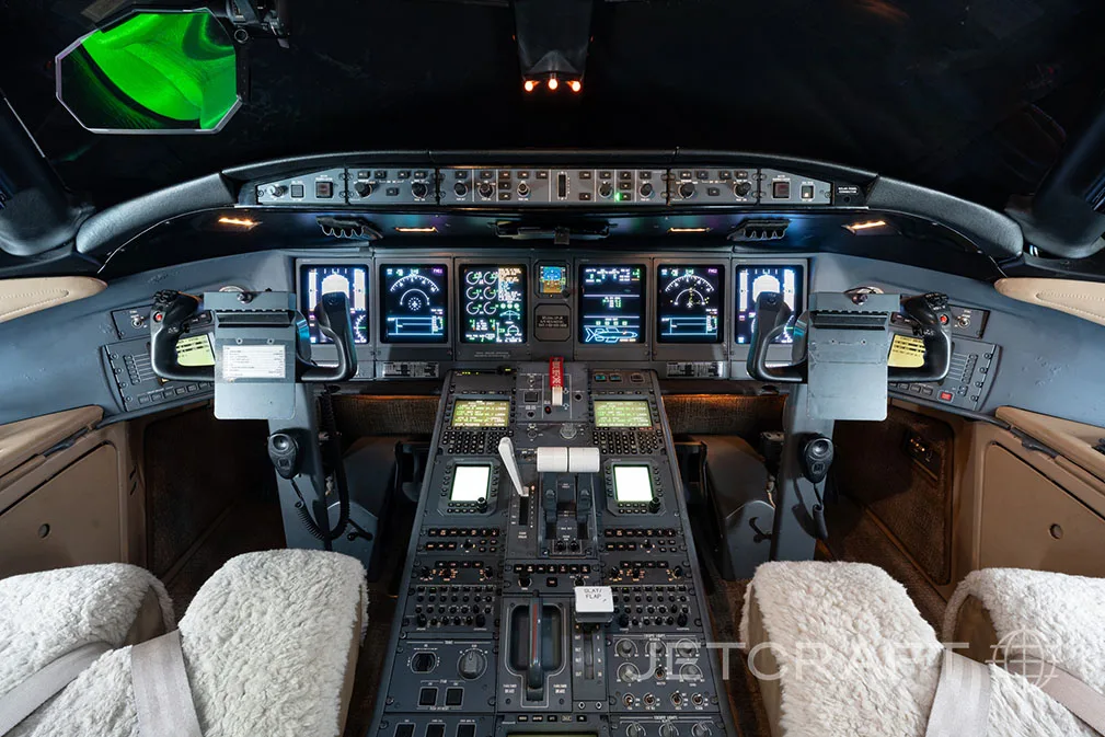 The cockpit of a Bombardier Global Express, showing the instrument panel with multiple displays and control yokes.