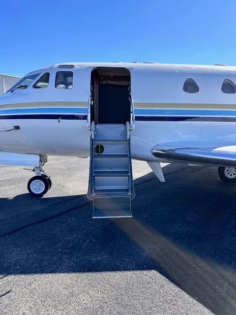 A close-up view of the open airstair door and front section of the N700JC business jet.