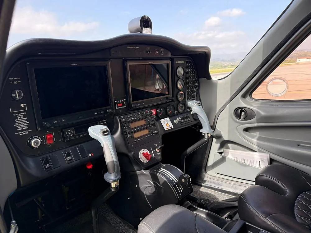 A wide view of the Tecnam P2008 cockpit, showing the instrument panel, dual control sticks, and pilot's seat.