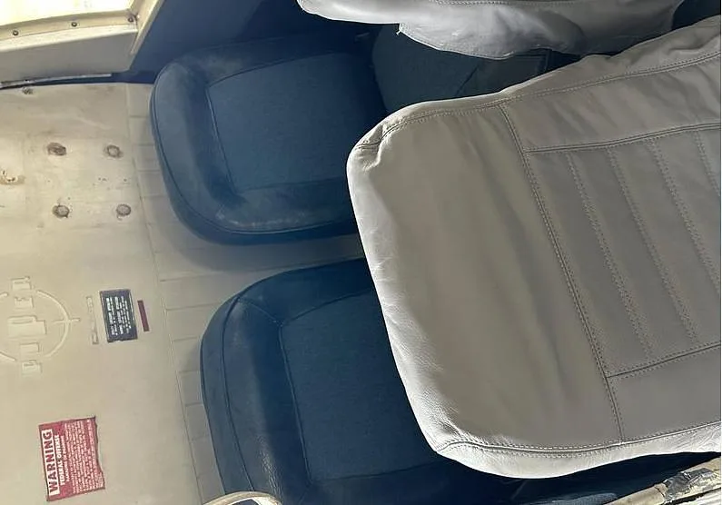 An overhead view of the aircraft's interior, showing two grey and black passenger seats.
