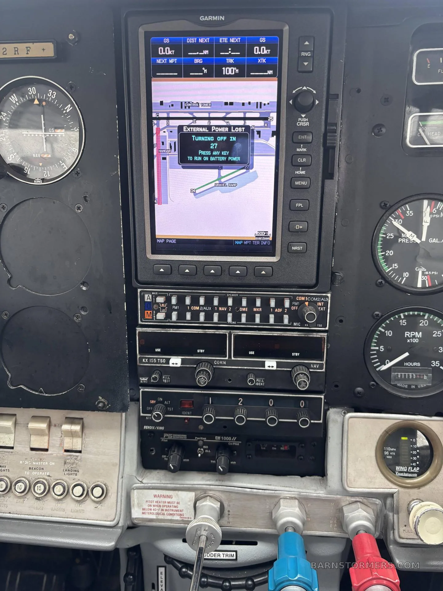 A close-up view of an aircraft's instrument panel, highlighting the GPS display showing "EXTERNAL POWER LOST" and various radio controls.
