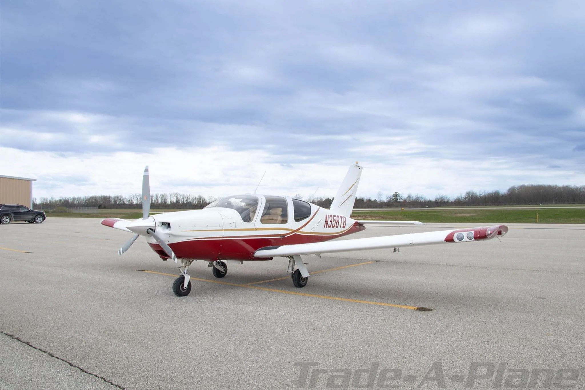 The aircraft is parked on a tarmac with a cloudy sky.