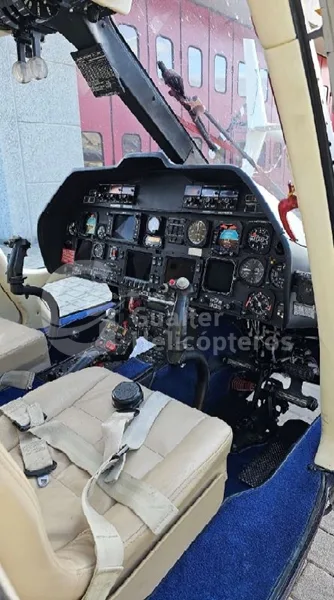 The instrument panel and controls of a helicopter cockpit, viewed from the pilot's seat.