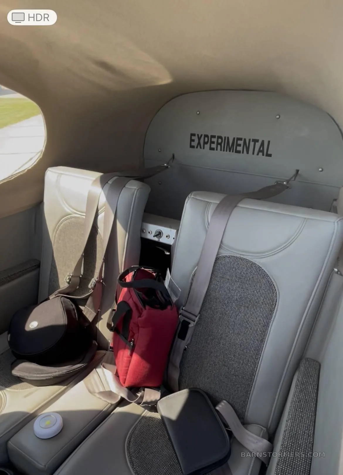 The aircraft's interior cabin features two light gray seats with seatbelts and the word "EXPERIMENTAL" on the bulkhead.
