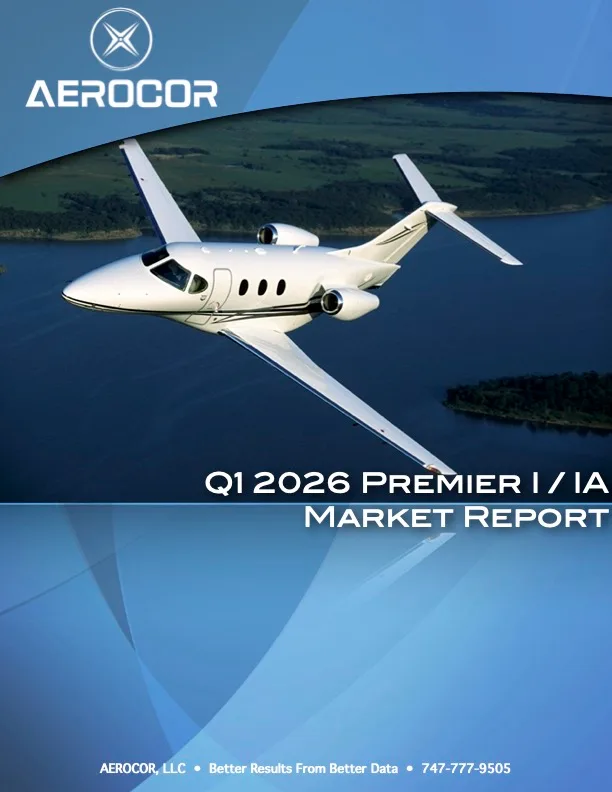 A white Premier I/IA business jet flies over a body of water with green land in the background.