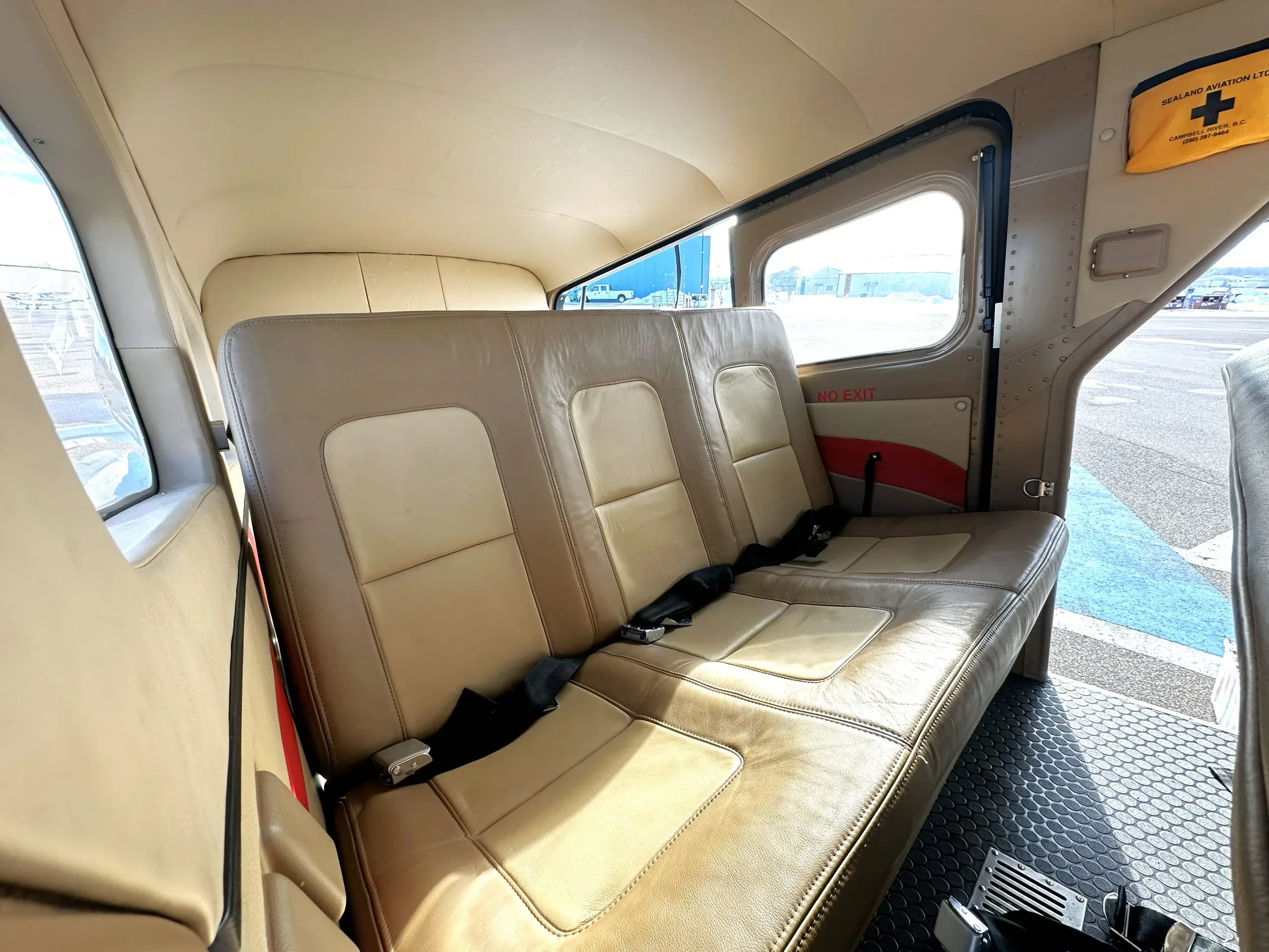 Angled view of the tan leather rear bench seat and cabin interior.