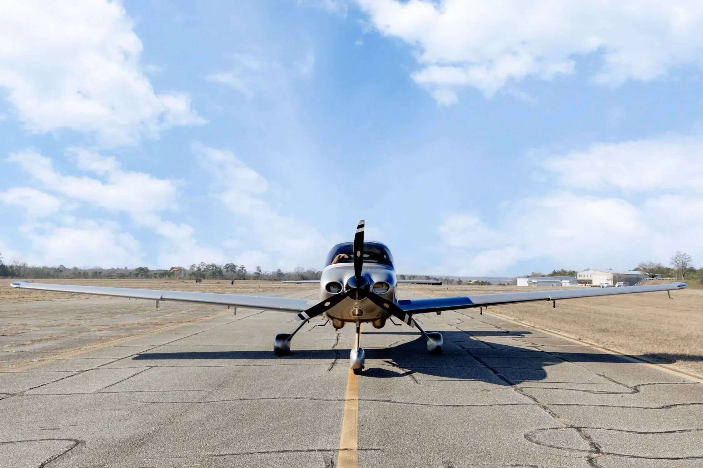 A head-on view of the Cirrus SR20 GTS aircraft with N667MT registration, centered on an airfield runway.