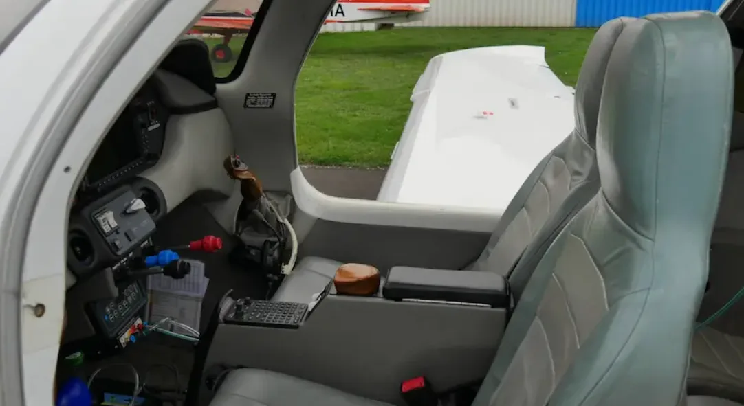 The interior of a Columbia 400 cockpit, showing the grey leather seats, side stick controls, and instrument panel.