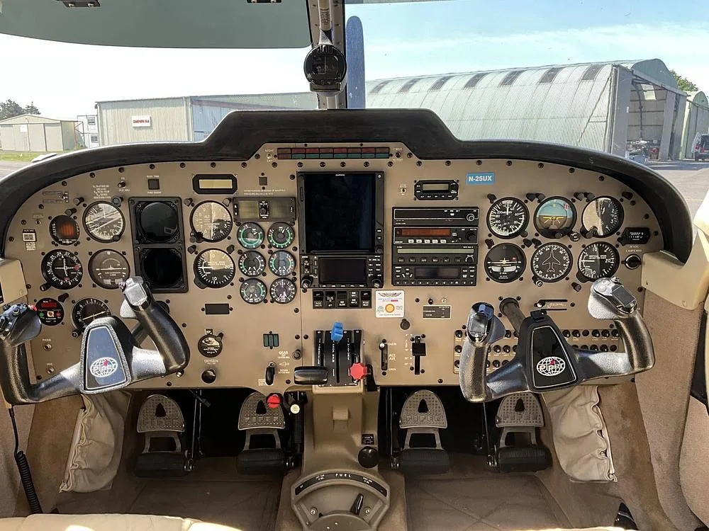 The cockpit of a Piper Saratoga, showing the instrument panel with dual yokes and various gauges.