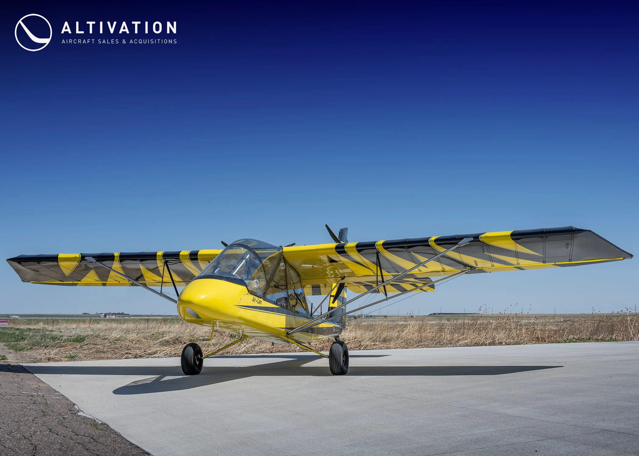 Yellow and black AirCam on the ground, side view.