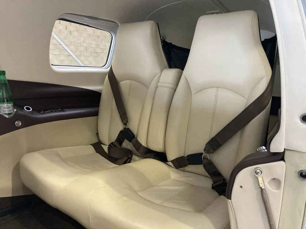 A view of the beige leather passenger seats in the aircraft's interior cabin.