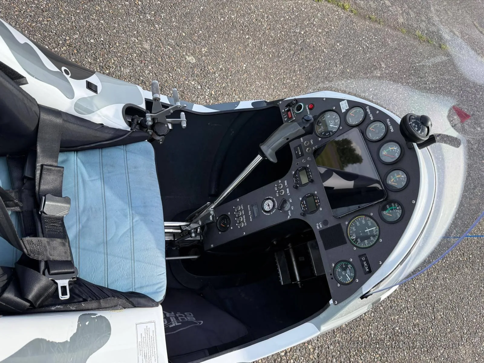 An overhead view of the MTO Sport gyrocopter's cockpit, showing the instrument panel, controls, and a light blue seat cushion.