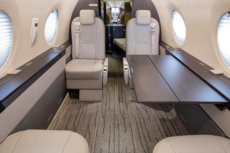 Interior view of the Nextant 400XTi cabin with leather seats and a table.