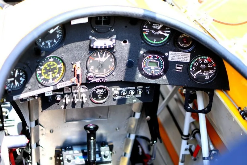 A close-up view of a small aircraft's cockpit instrument panel with various gauges and switches.