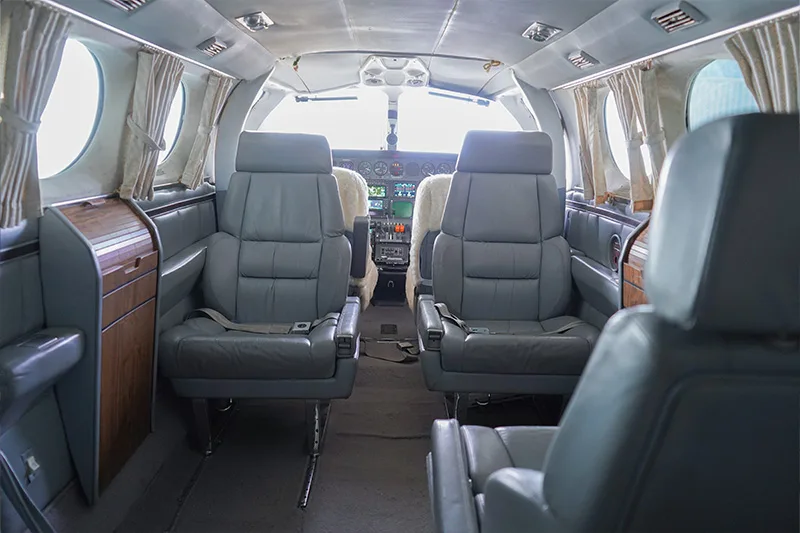 The interior of a Cessna 421 Golden Eagle aircraft features leather seats and wood trim.
