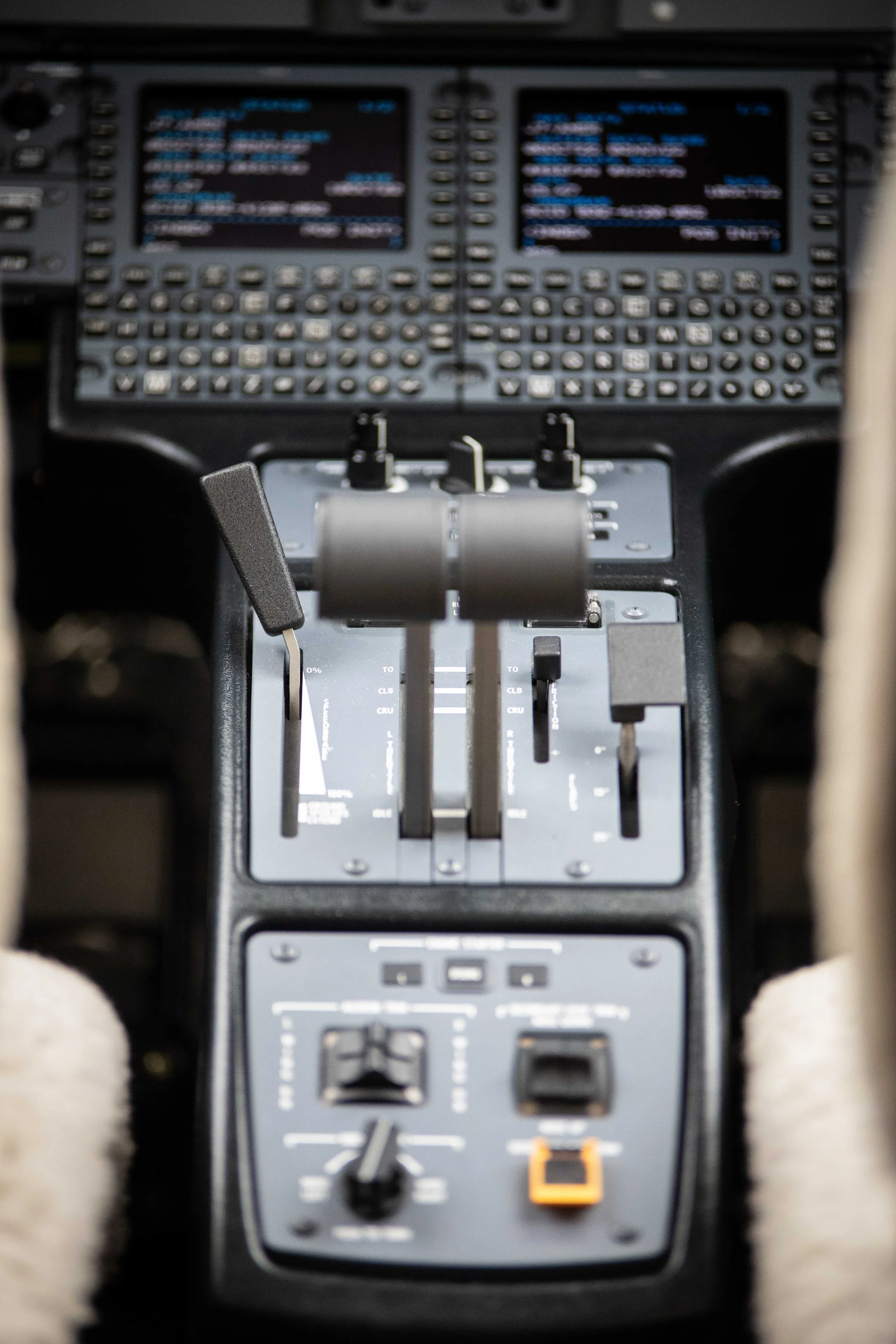 An overhead view of an aircraft's throttle quadrant and lower control panels.