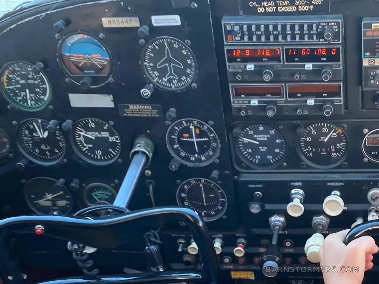The instrument panel of a Cessna 182 aircraft with various gauges and controls.