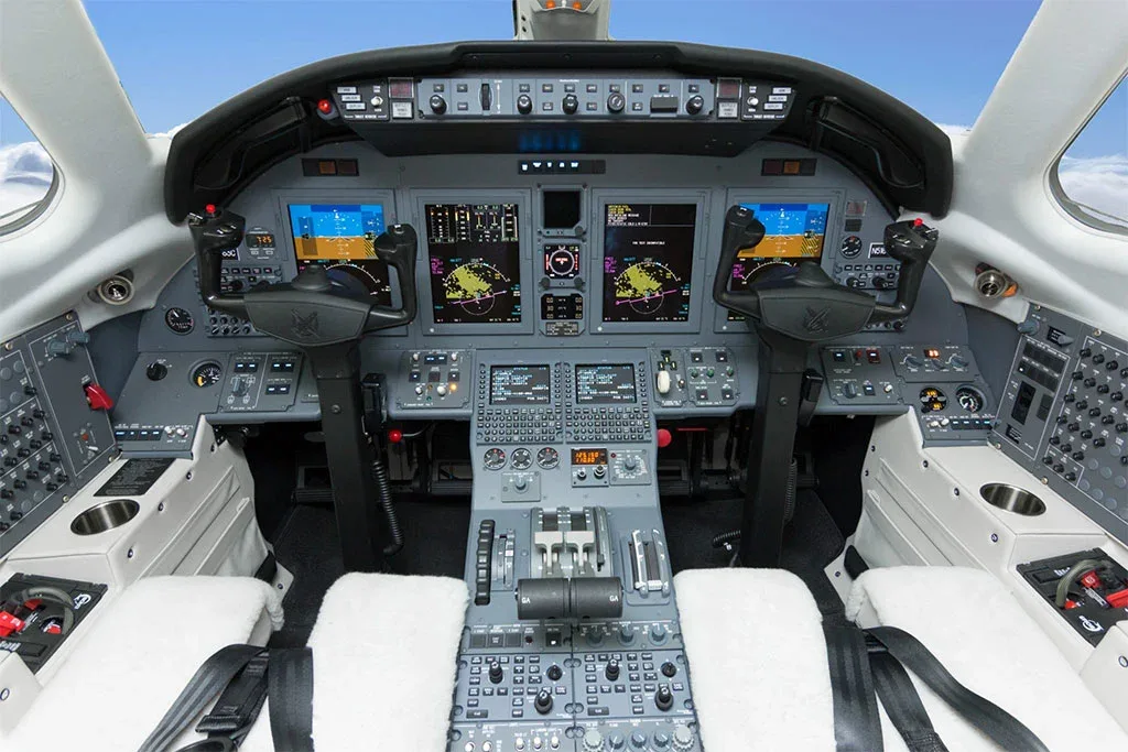 The cockpit of a Citation XLS+ aircraft, featuring multiple digital displays and a complex control panel.