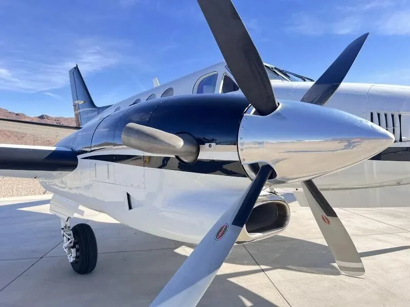 A detailed view of the right engine and propeller of the white and black turboprop aircraft.