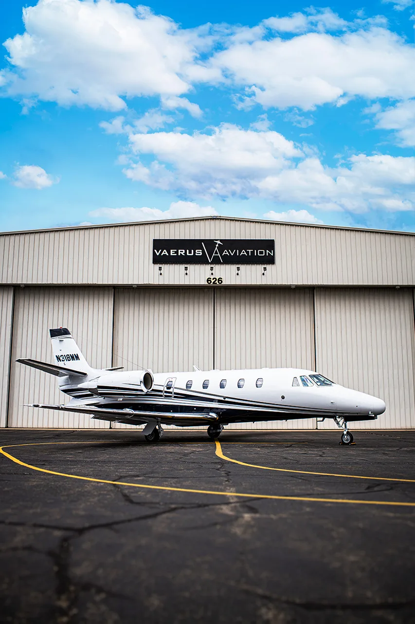 A Cessna Citation CJ3 aircraft, registration N318MM, is parked in front of a Vaerus Aviation hangar.