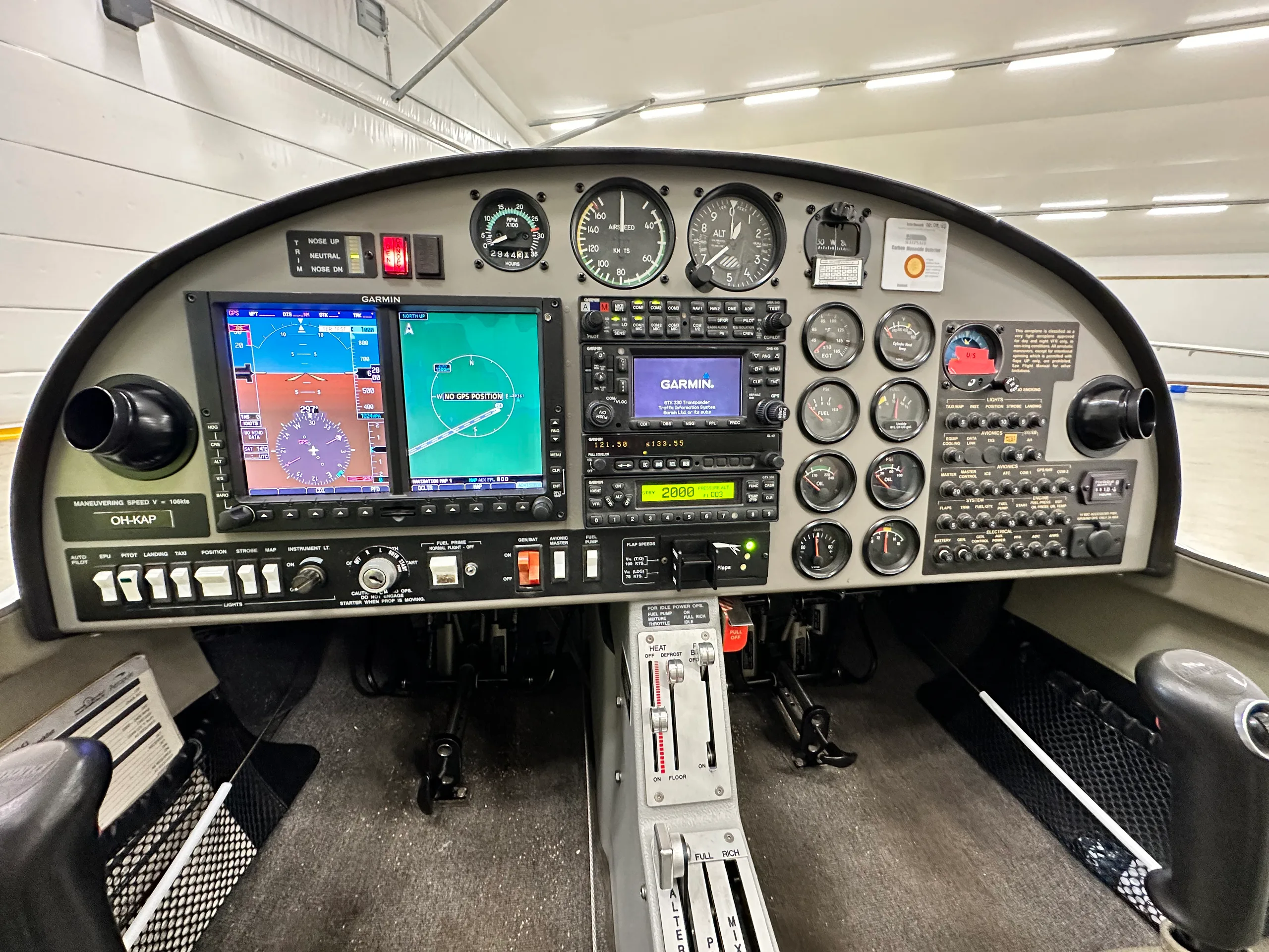 A detailed view of a Diamond DA20 cockpit instrument panel, featuring Garmin displays and traditional analog gauges.