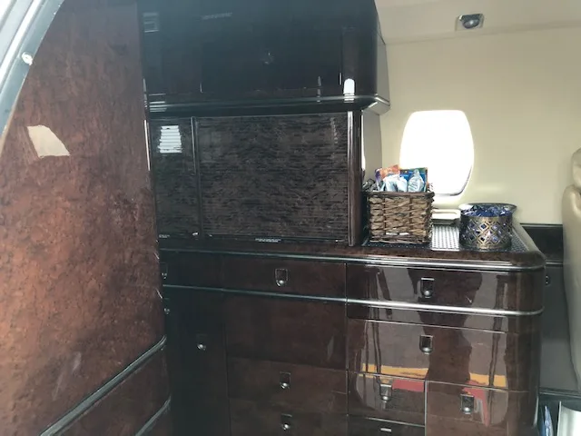 Interior view of the aircraft with wooden cabinets and a small window.