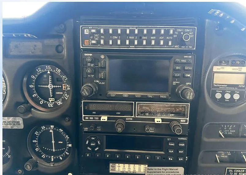 A close-up of the avionics stack in the cockpit of a Piper Cherokee C, featuring Garmin and King radios.